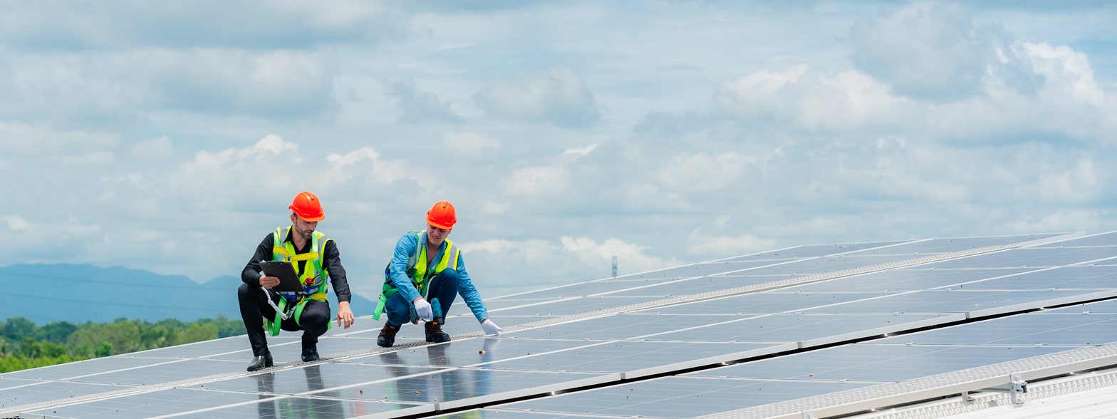 Workers installing solar panels on rooftop, representing renewable energy projects and field crew activity