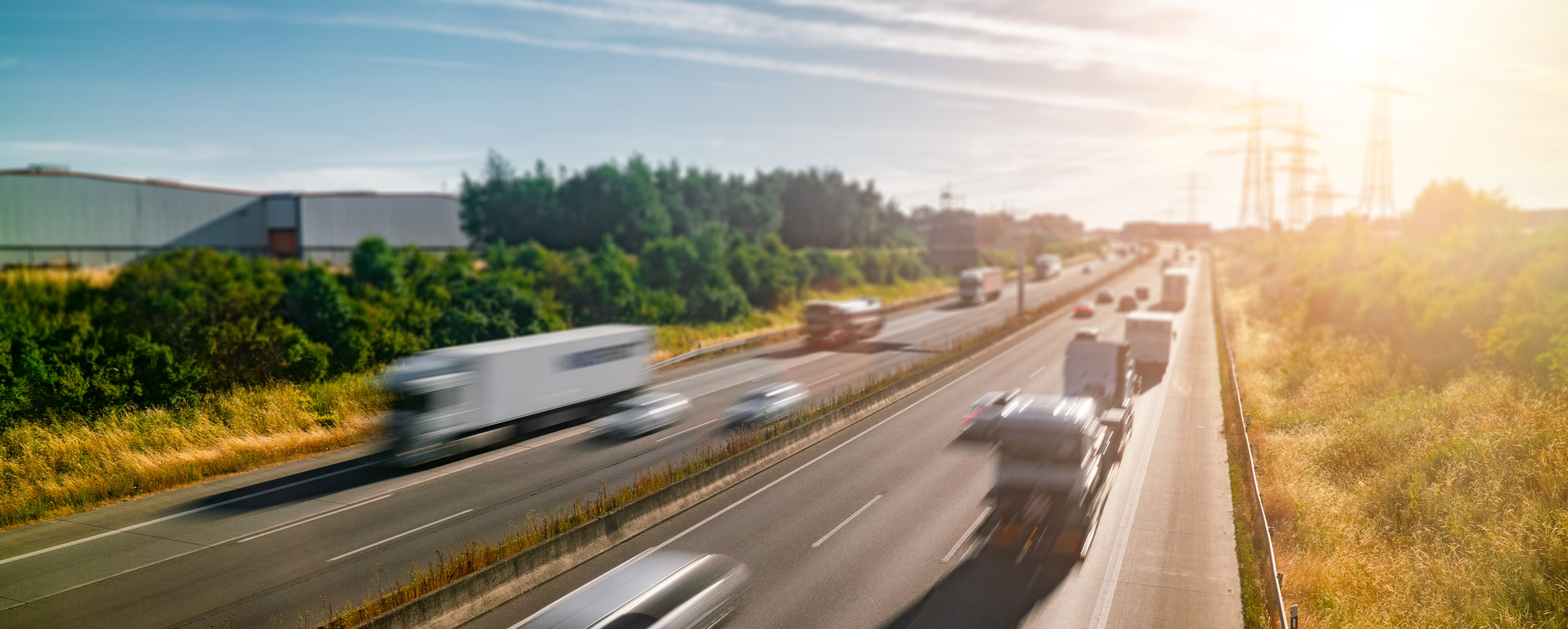 Vehicles traveling on highway at sunset, representing crew travel between job sites and workforce mobility
