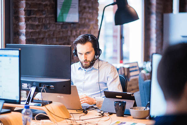 A person wearing headphones and using a computer