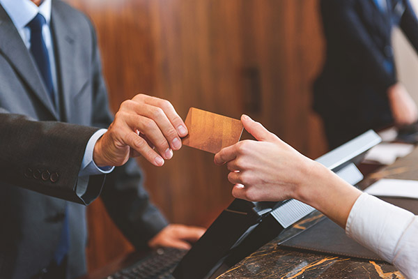 A hotel employee handing a key card to a customer