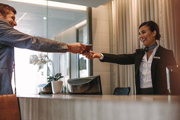 A hotel employee handing a key card to a customer