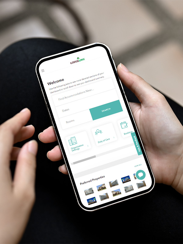 A person holding a cell phone looking at LodgeLink's welcome page.