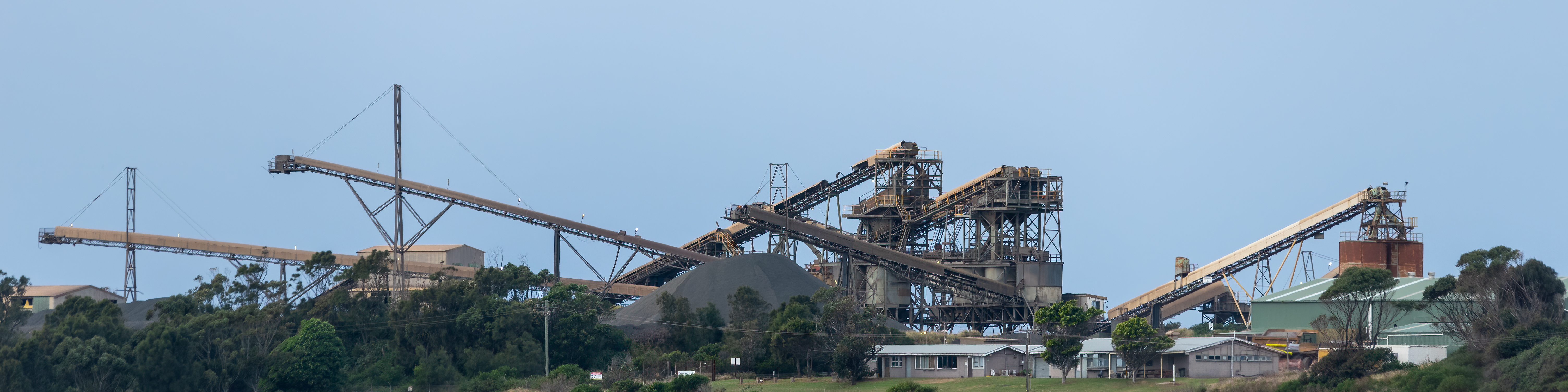 Panoramic view of mining conveyors and industrial equipment against a clear sky.