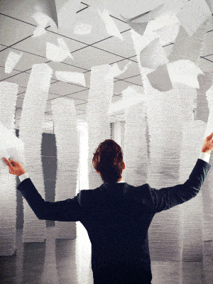 A person standing throwing many pieces of paper.