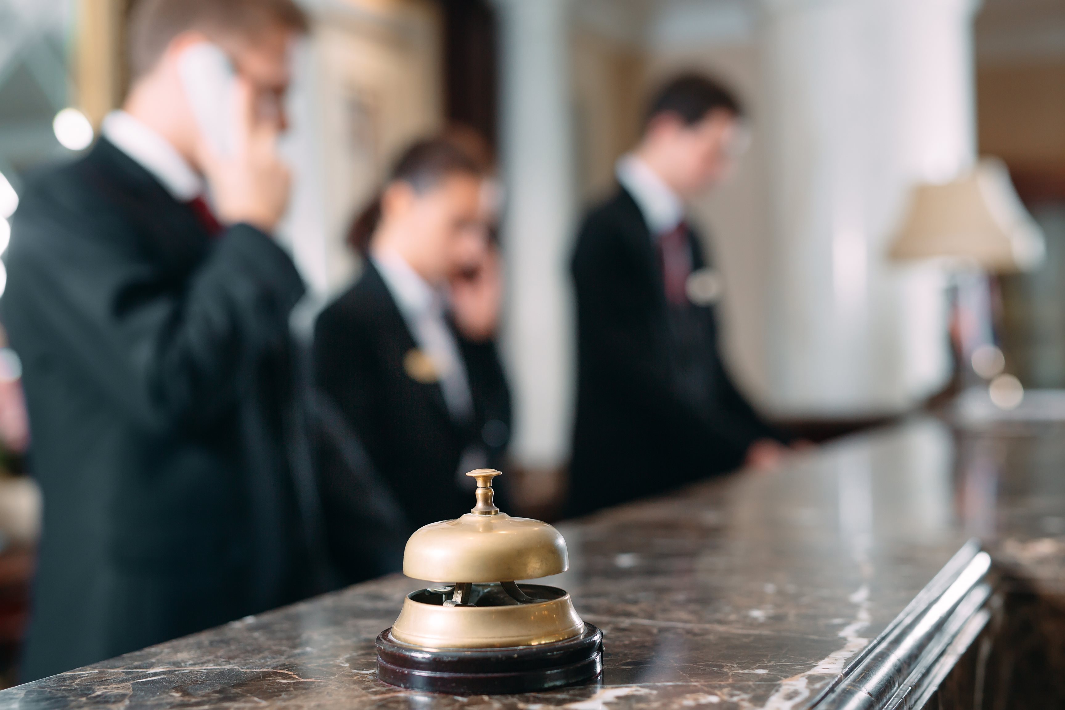 A bell with hotel staff in the background