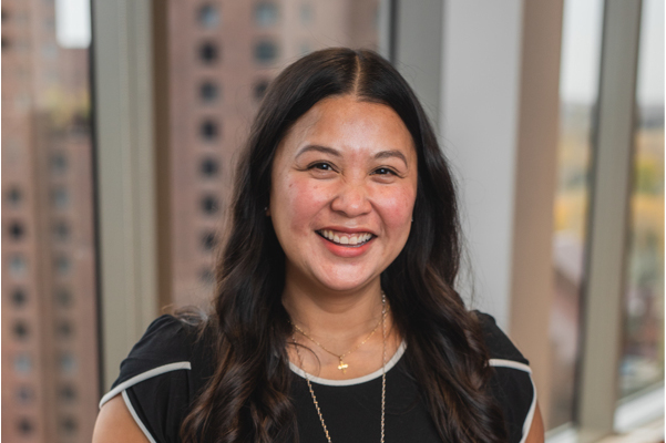 Professional headshot of LodgeLink team member with long dark hair, smiling indoors by window.