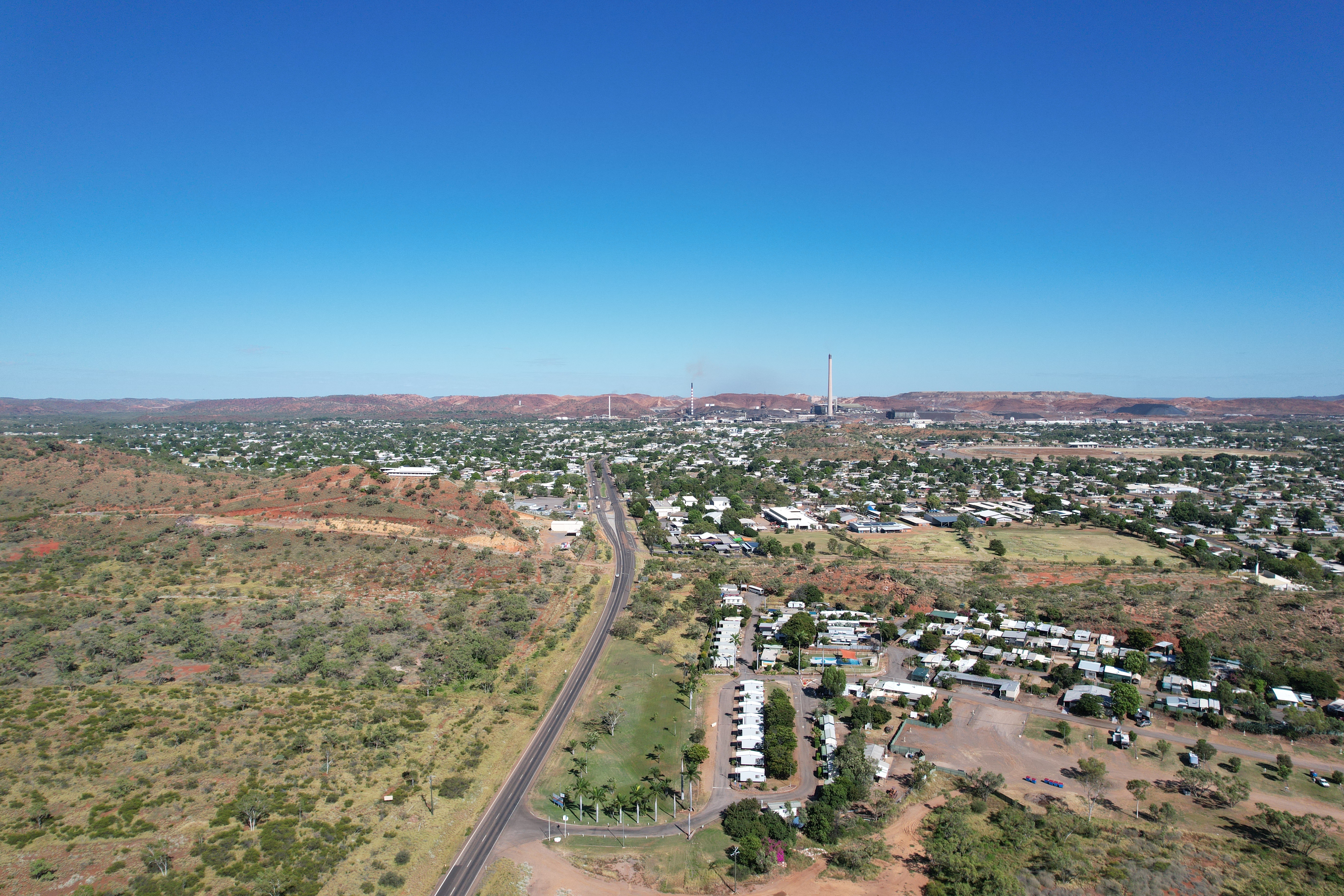 Aerial view of an Australian mining town surrounded by red earth and desert landscape.