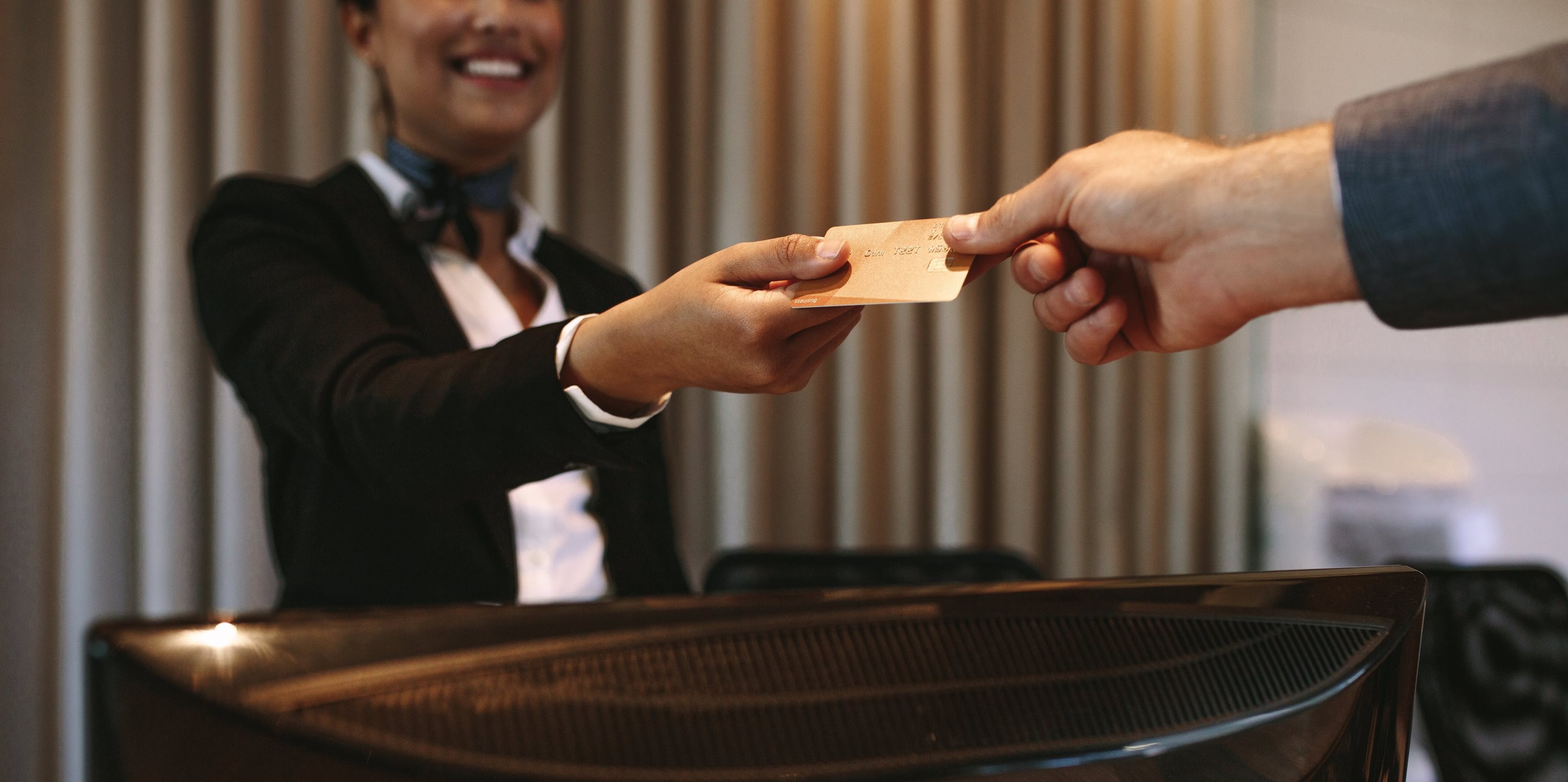 A hotel employee giving a customer a key. 