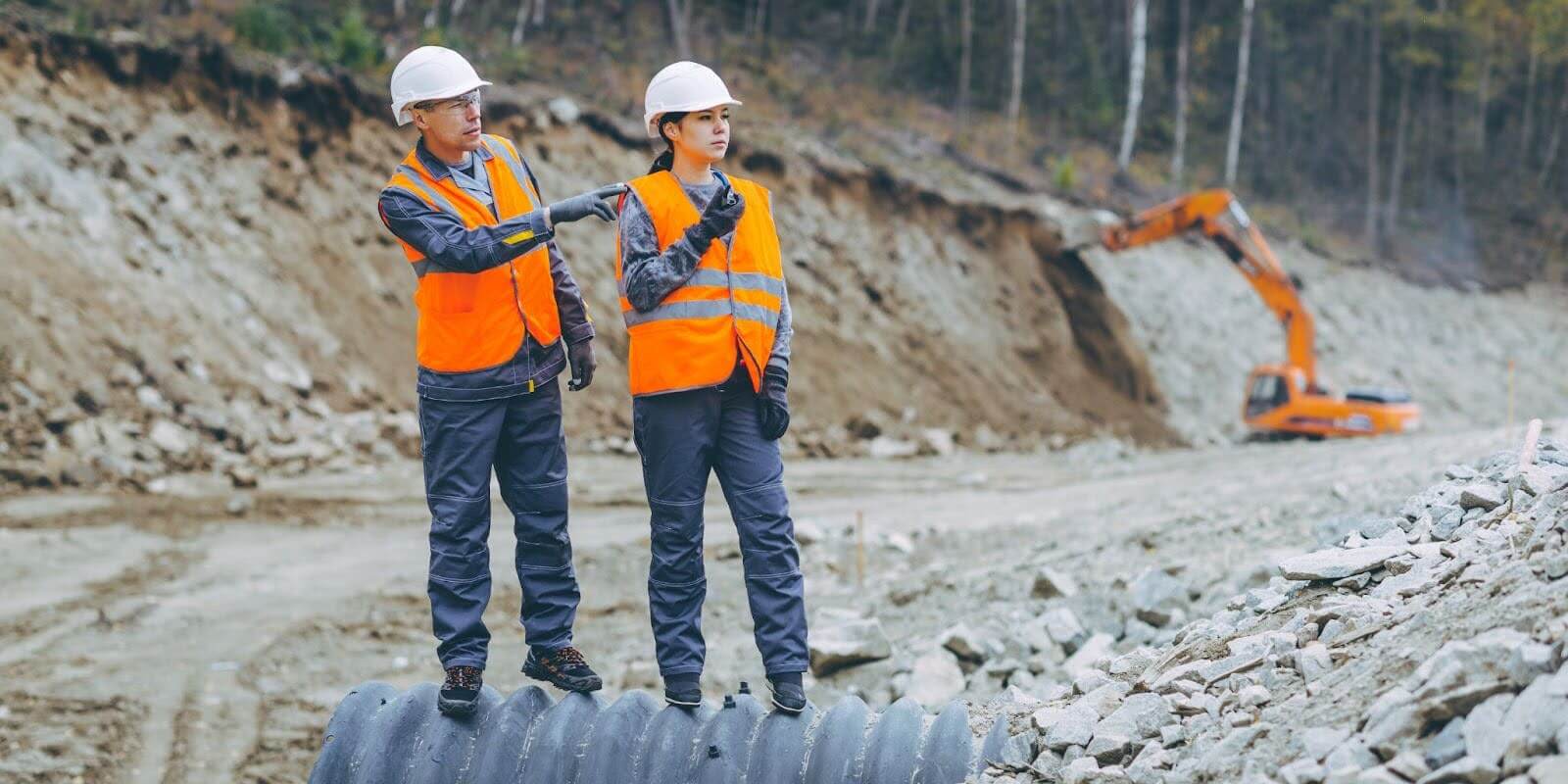 A group of people in orange vests and white helmets on a construction site