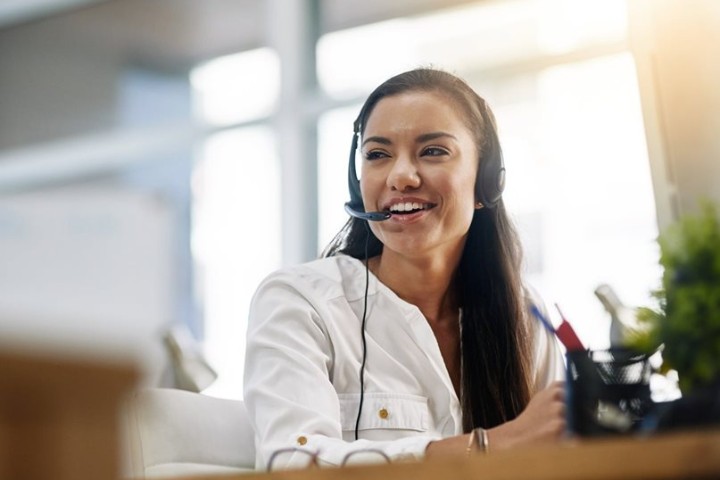 LodgeLink customer support advisor wearing a headset providing 24/7 workforce travel booking assistance
