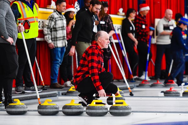 LodgeLinks CTO in a red flannel shirt curling