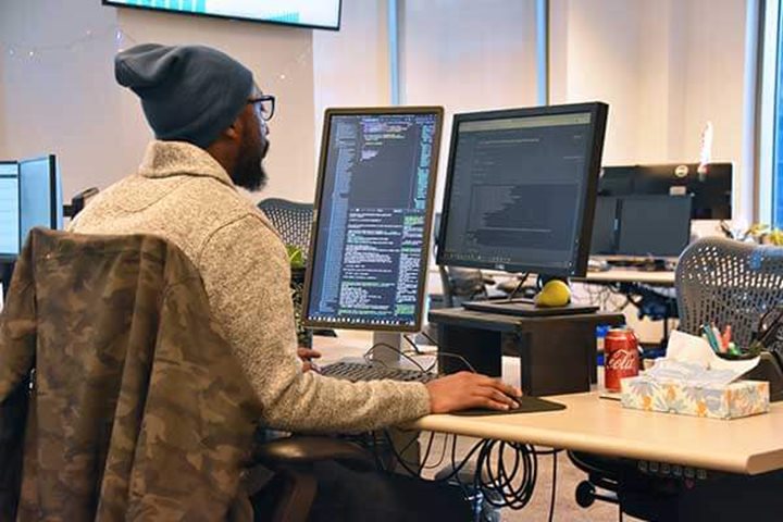 A software engineer sitting at a desk coding