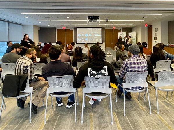 A group of people sitting watching a presentation