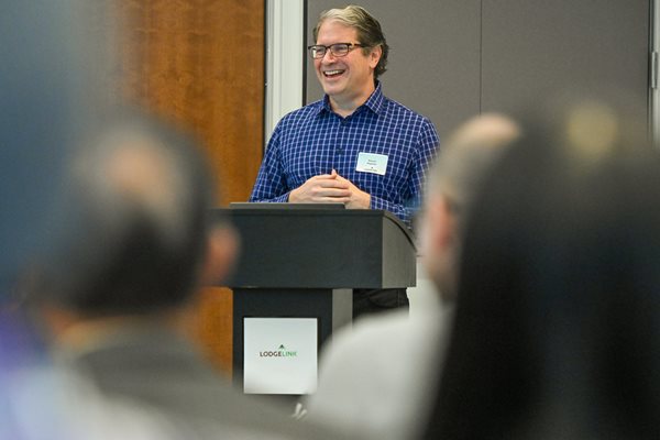 The President and CEO of LodgeLink standing at a podium