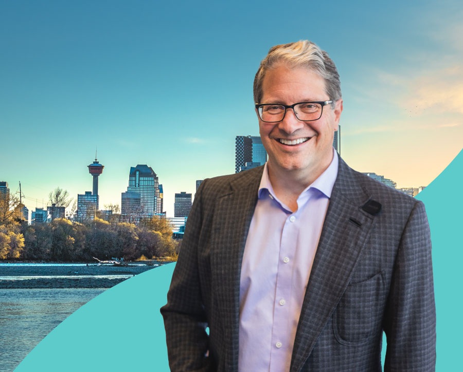 LodgeLinks CEO and founder in a suit smiling in front of the city of Calgary