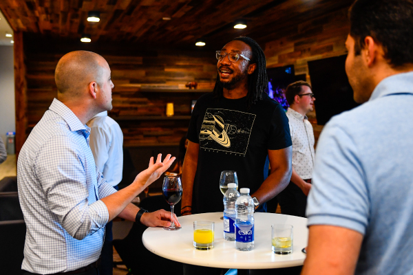 Co-workers enjoying drinks and talking at an event 