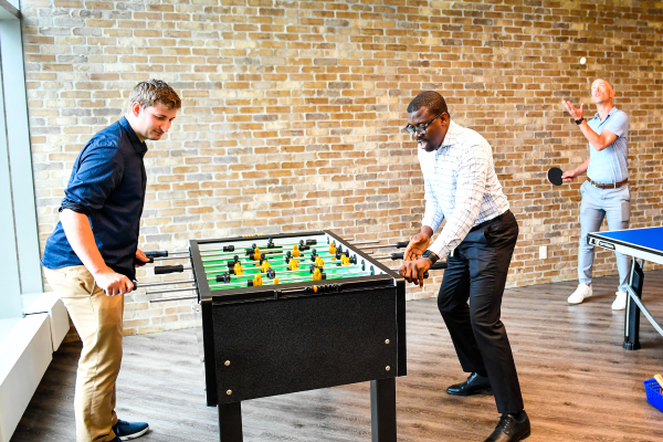 A group of colleagues playing foosball at an employee engagement event