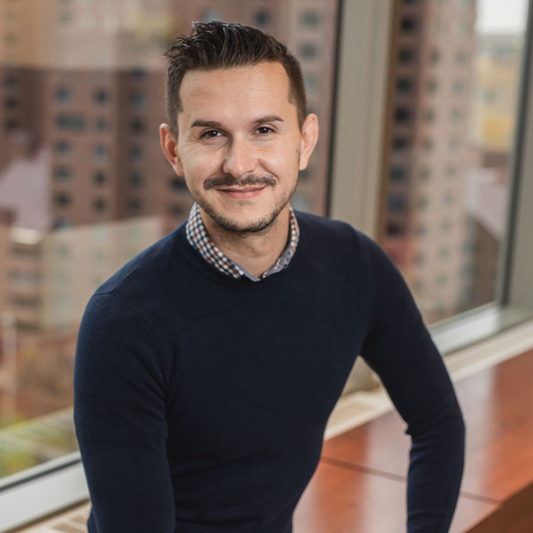 The manager of Customer Experience sitting on a bench posing for a photo