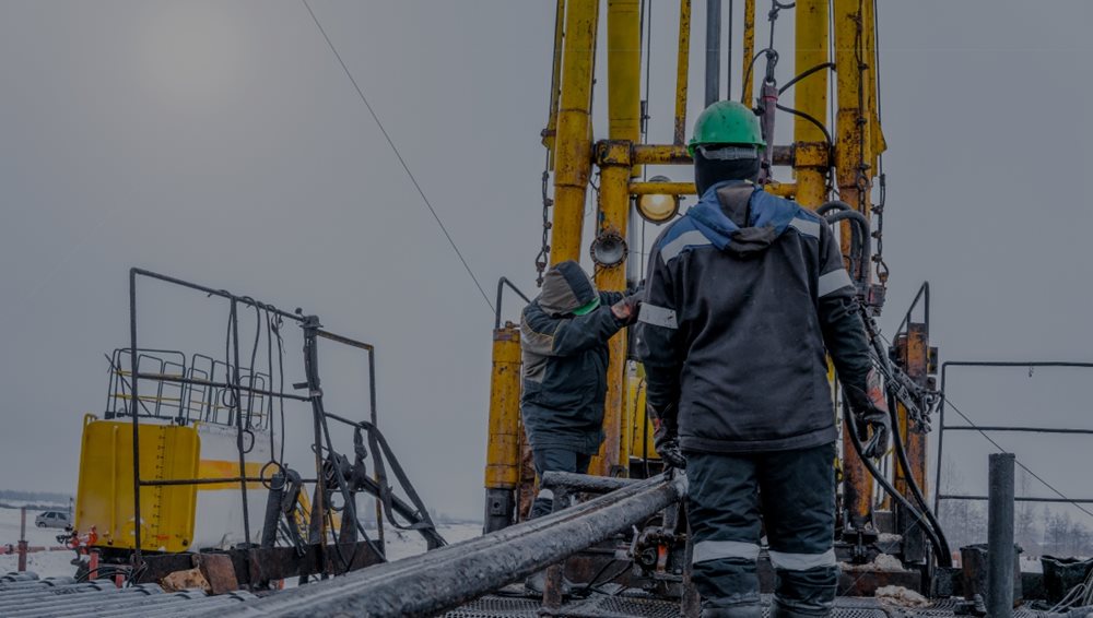 A group of men in hard hats and helmets on a fracking work site