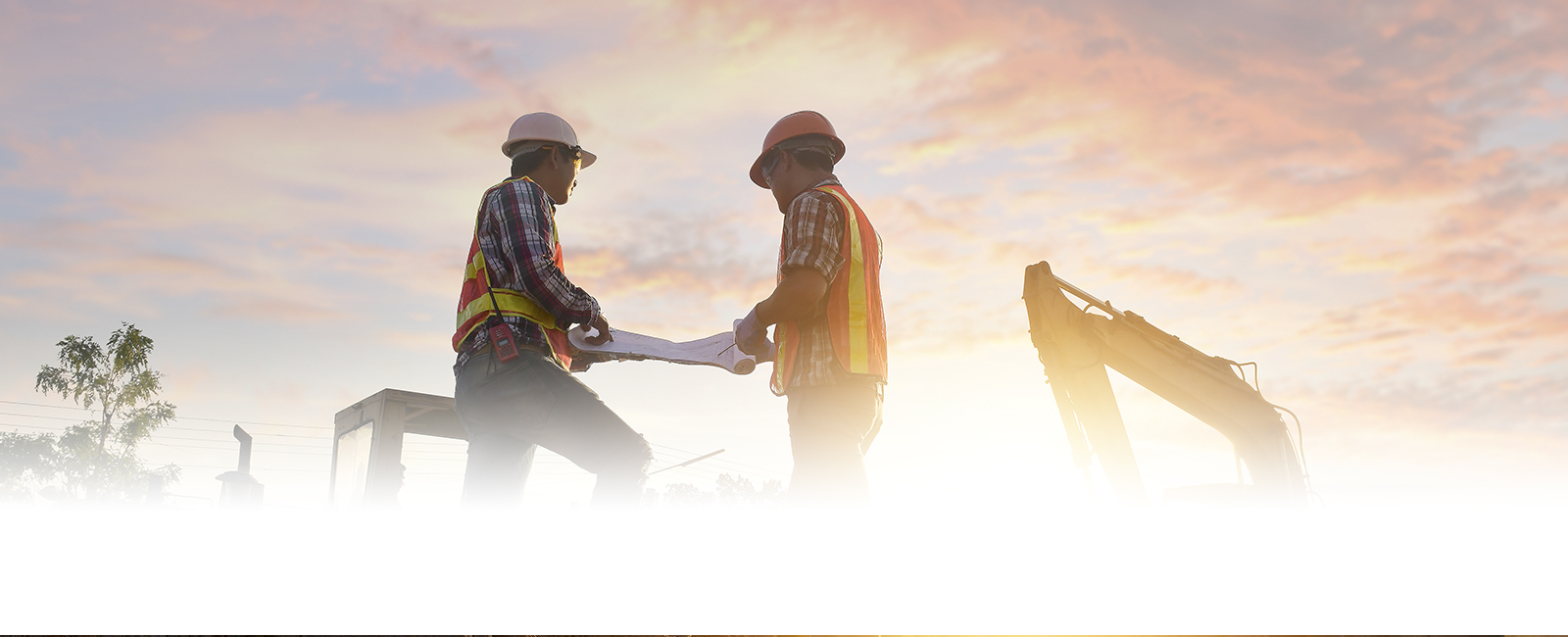 Two people in hard hats talking