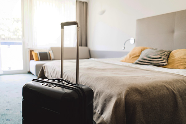 A suitcase next to a bed