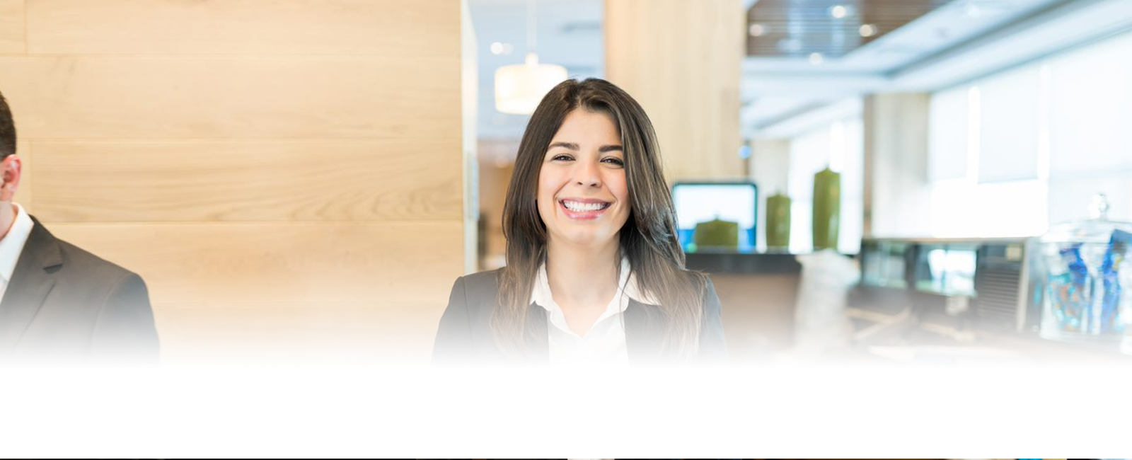 A person standing at a reception desk with the LodgeLink logo 