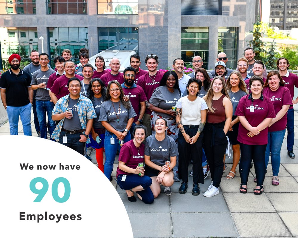 A group of LodgeLink employees posing for a photo with a statistic about employee growth