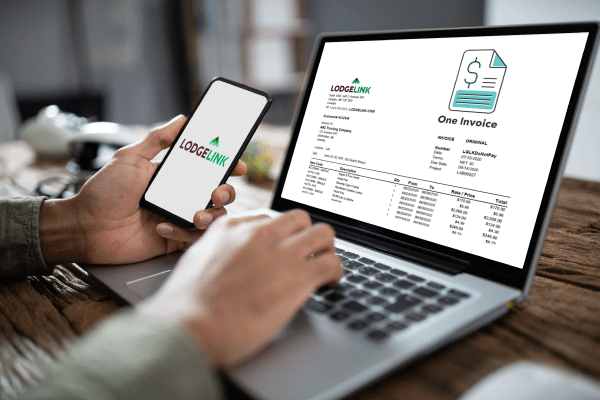 A workforce travel invoice showing up on a laptop with the logo of LodgeLink on a phone.