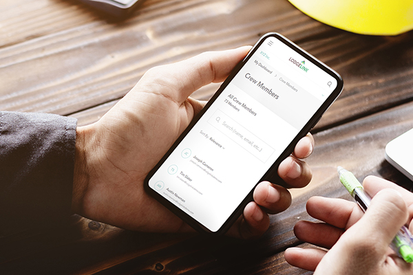 A hand holding a phone displaying a crew list on the LodgeLink app