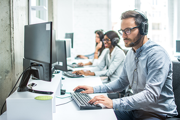 A group of people working on computers in a call center