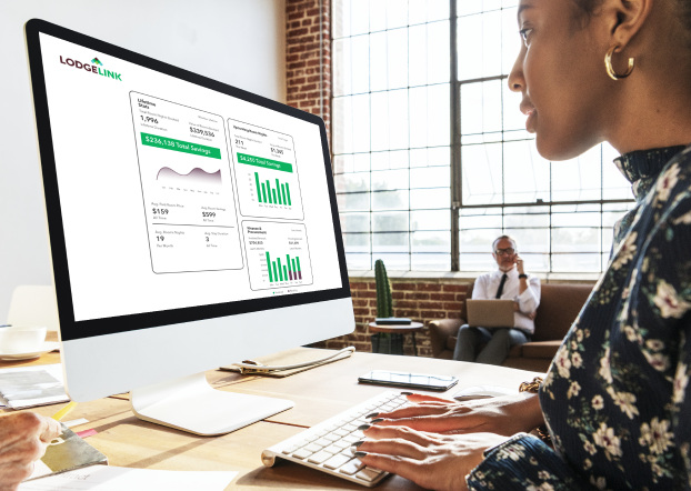A woman on a desktop using LodgeLink workforce travel technology.	
