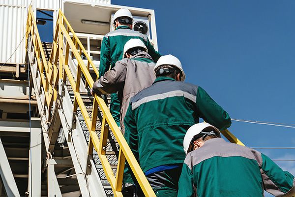 Group of workers going up stairs to a work site.