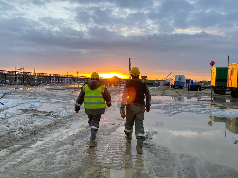 Two people walking toward a work site